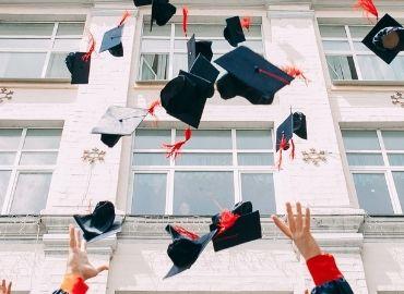 People throwing graduation caps into the air